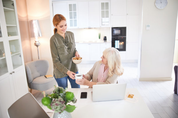 快乐的老年妇女从女志愿者手中接过热饮图片下载