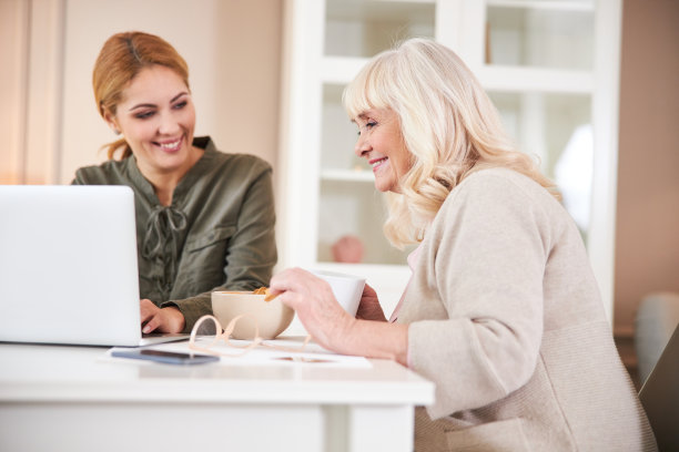 在房间里用笔记本电脑打字的快乐女人图片下载