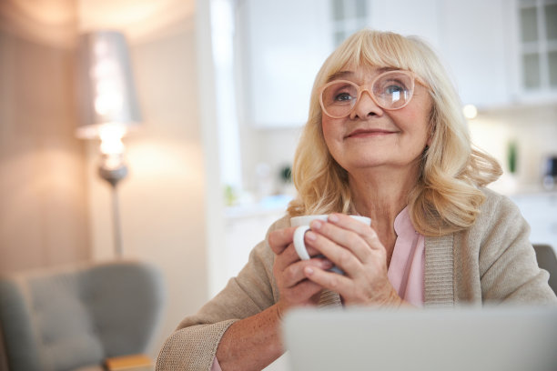 微笑成熟的女士在家里享受热饮图片下载