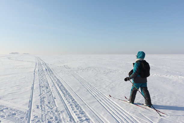 快乐的女人与一个照片袋，背包和摄像机，滑雪在结冰的河流上，Ob水库，新西伯利亚，俄罗斯图片下载