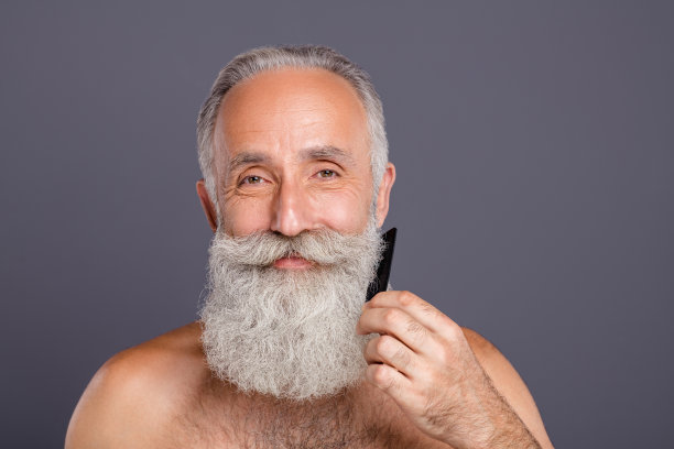 特写照片的老英俊的男人都市美男梳理整洁长胡子爱自己看着镜子浴室赤膊孤立的灰色背景图片下载