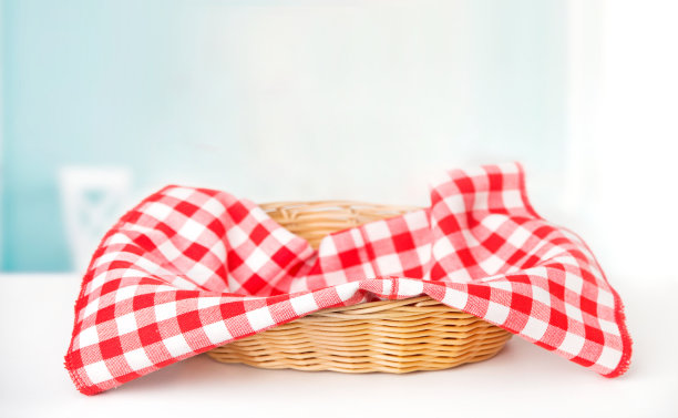 白色的桌子上放着一个柳条篮子，里面有红色的格子布，还有节日的墙纸图片下载