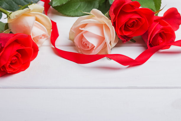 红色和柔和的颜色的玫瑰和红色丝带木桌特写。图片下载