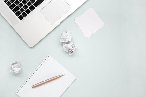工作和创造力的概念。笔记本电脑，记事本，纸球和笔俯视图平放照片与copyspace。电脑和文书工作。办公室上面图片下载