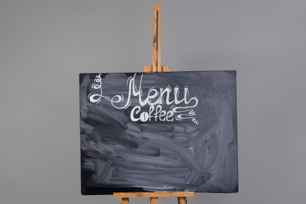 黑色的黑板上有咖啡菜单和抹去的粉笔条纹。站在木画架上，孤立在灰色的背景上图片下载