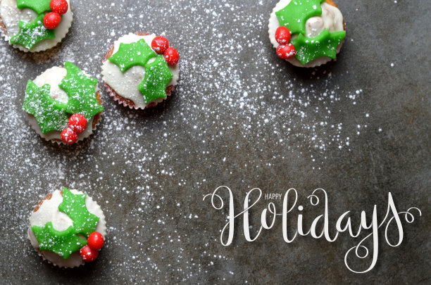 节日快乐，用毛笔在石头上写横幅，背景是纸杯蛋糕图片下载