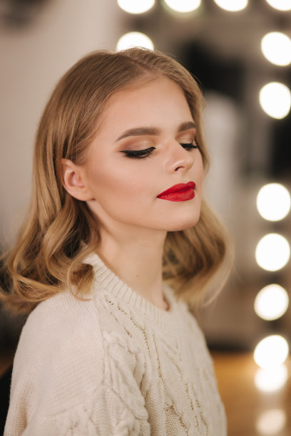 迷人的年轻女士化妆后在美容工作室。涂着红唇的漂亮女人图片下载