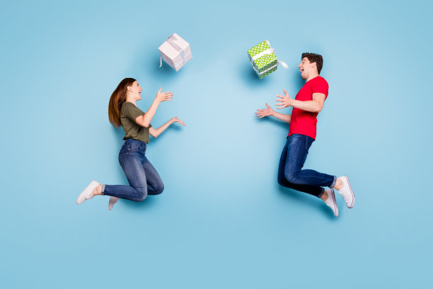 两个疯狂的已婚人士的全长侧面照片学生庆祝14日2月跳高假日扔礼盒下落穿休闲风格的衣服运动鞋孤立的蓝色背景图片下载