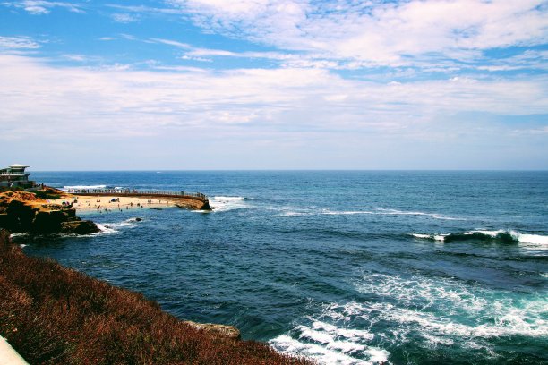 碧绿的海水，悬崖，游客码头，地平线上的蓝天。图片下载