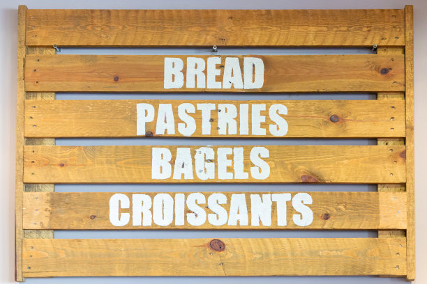 木制招牌上的面包、糕点、百吉饼和牛角面包图片下载