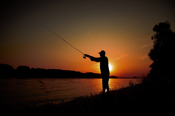 日落时分，人们在河边钓鱼图片下载