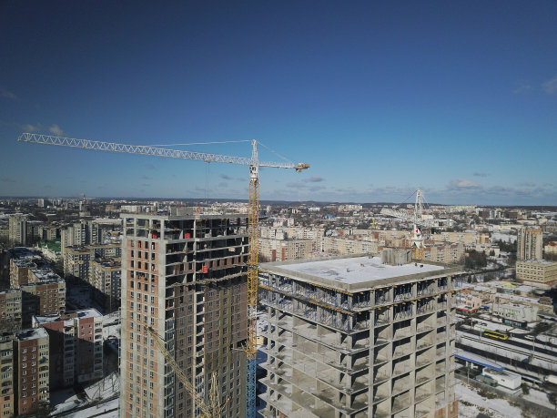 利沃夫，Sychiv，乌克兰——2020年2月7日:塔式起重机在多层建筑施工期间工作。新建居民公寓和办公楼。高空作业有风险。图片下载