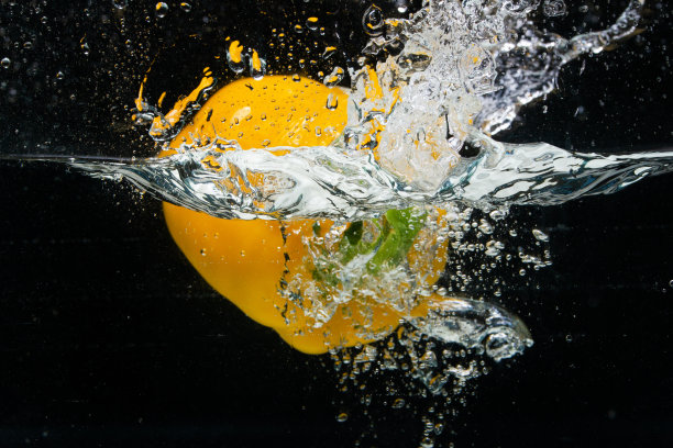 保加利亚甜橙辣椒落在水中，喷洒设计，在运动中冻结图片下载