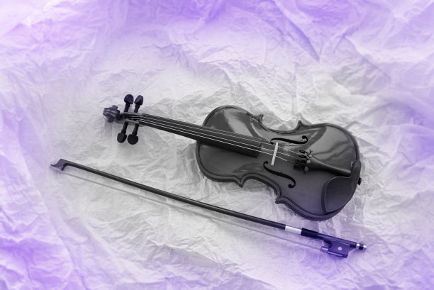 黑色调粗糙背景上的小提琴和琴弓图片下载