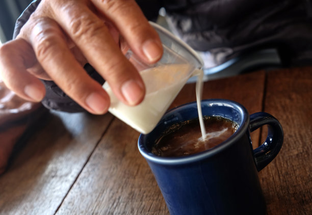 老人把牛奶倒进咖啡里图片下载