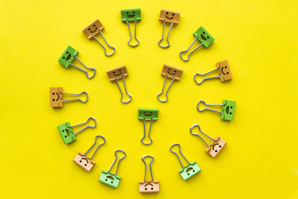 彩色回形针与微笑在黄色的背景图片下载