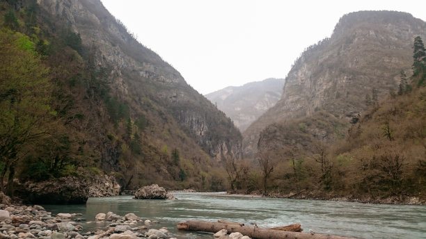 山河的岸边长满了苔藓，岩石的背景上有一个湖图片下载