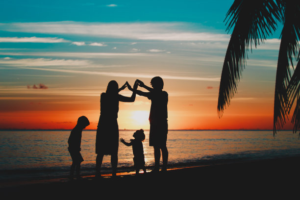 幸福的一家人和孩子们在日落海滩上玩耍素材图片