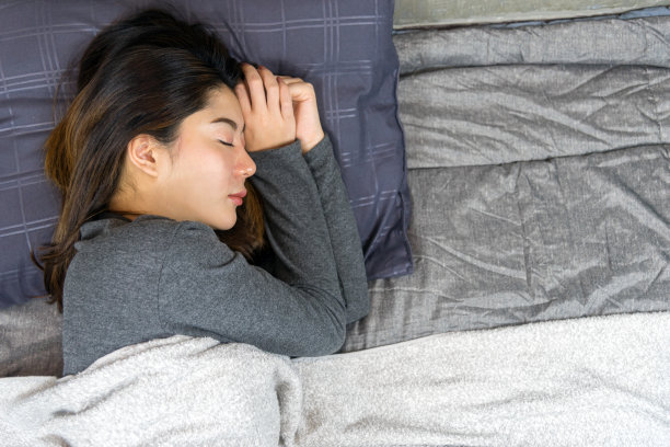 睡在床上的女人。素材图片