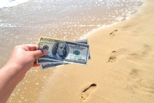 手持300美元钞票，背景为海洋的女孩图片下载