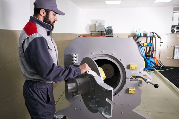 洗衣服务中，男工人们从自动洗衣机里取出地毯，然后放入烘干机图片下载