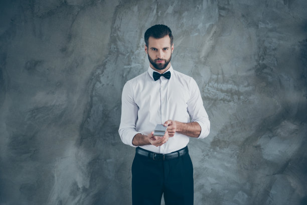 照片严肃自信的人胡子更尖锐的赌场卡大师与鬃毛准备开始扑克游戏孤立在灰色墙壁混凝土颜色的背景图片下载