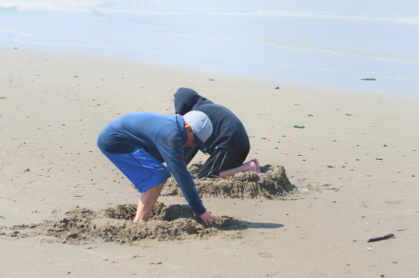 男孩们在林肯市的沙滩上滑行，海岸海滩。图片下载