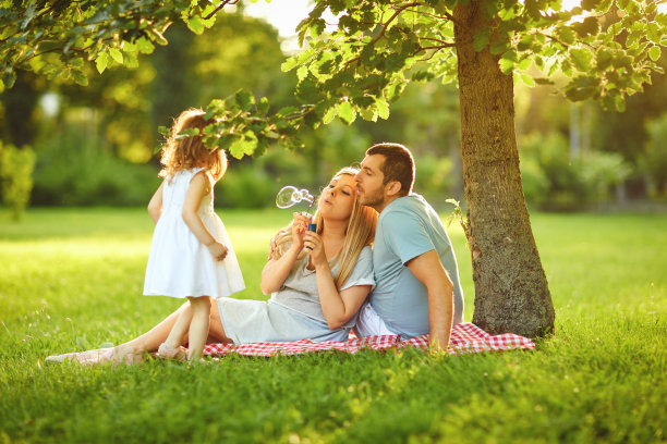 在公园草地上和婴儿在一起的家庭图片下载