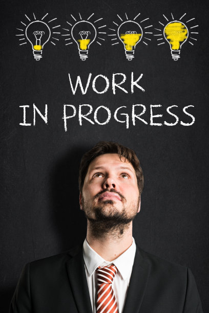 在写有“工作中”信息的黑板前的商人图片下载