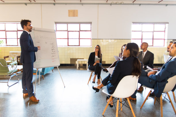 侧视图，自信的演讲者站在白板附近图片下载