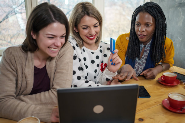 美丽的年轻女子多民族妇女在网上购物的咖啡馆图片下载