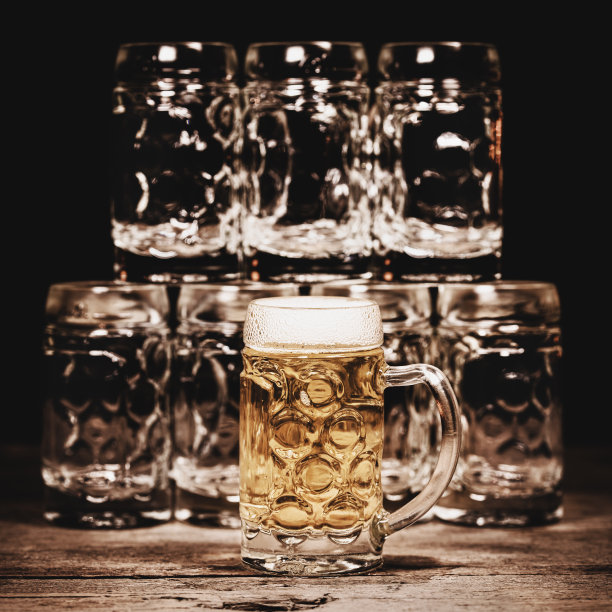 啤酒杯或酒壶放在木桌上，推广美食，酒吧和酒馆，啤酒文化，广场图片下载