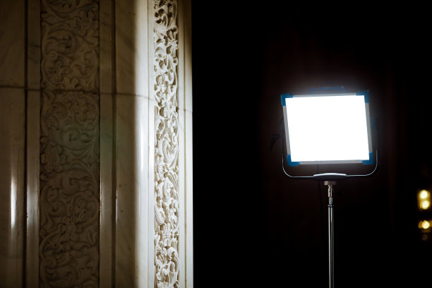 强大的工作室灯光靠近白色大理石柱子与黑暗的背景图片下载