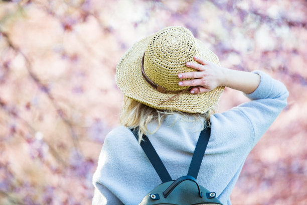 戴草帽的美丽女人在樱花公园旅行图片下载