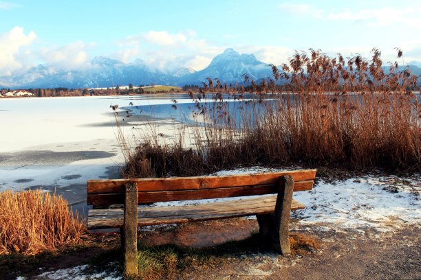 木制长凳，俯瞰冰冻的湖面，背景是群山，Allgäu图片下载