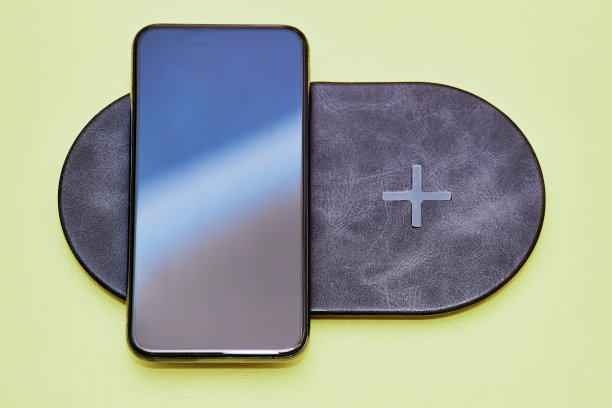 现代智能手机依赖于双重现代无线充电。通过空气传输电力。技术最新，技术精益求精。哑光橄榄色背景图片下载