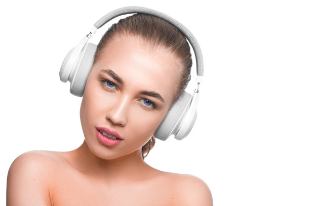 一个蓝色眼睛的女人戴着耳机看着相机的特写照片。图片下载