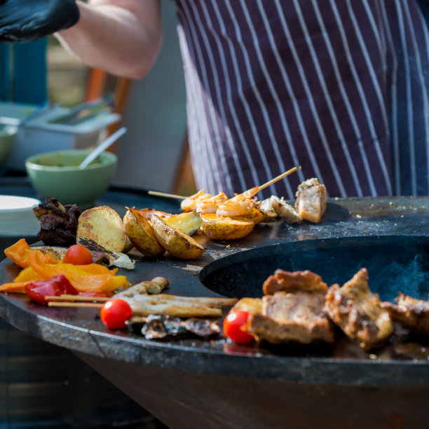 男人正在烧肉，鱼和蔬菜，特写。木炭烤架。拉脱维亚图片下载