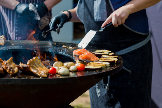 男人正在烧肉，鱼和蔬菜，特写。木炭烤架。拉脱维亚图片下载