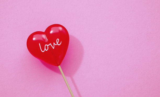 爱的概念-爱写在心形棒棒糖在粉红色的背景图片下载