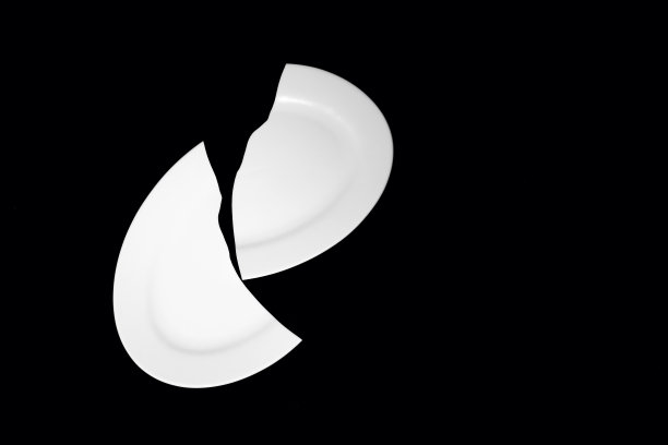 黑色背景上的碎白瓷盘图片下载