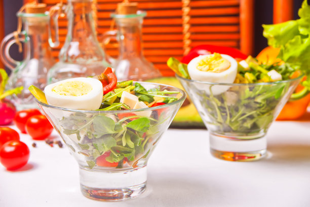 白色桌子上两个碗里的新鲜混合蔬菜沙拉图片下载