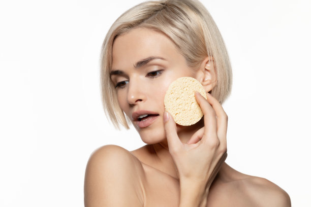 女人用化妆海绵洗脸。图片下载