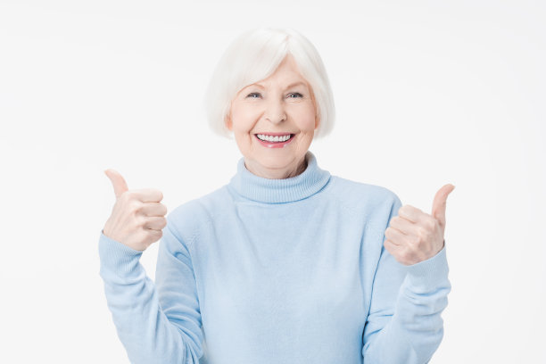 年长的女人在白色的背景下竖起大拇指微笑图片下载