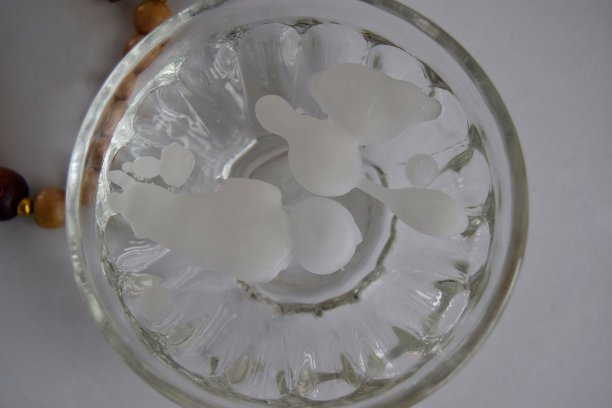 神秘的静物画。燃烧的蜡烛，一碗水和一串念珠在一个明亮的背景。预言的概念，千里眼。软的焦点。图片下载