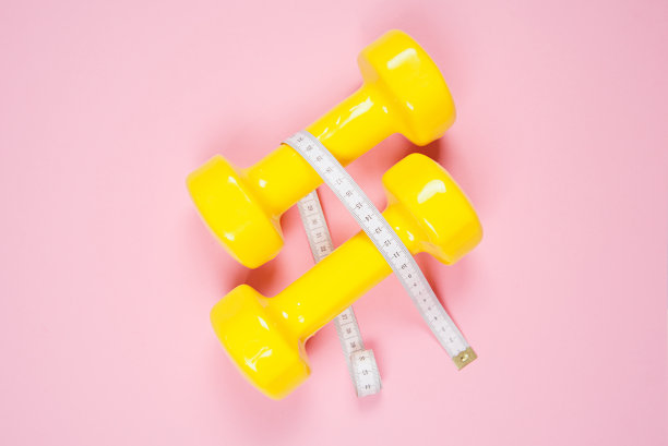 平躺拍摄的哑铃在粉红色的背景。体育的概念。图片下载