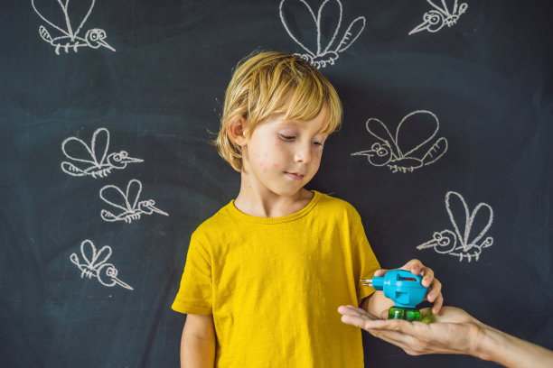 在黑暗背景下，男孩手持蚊香器被蚊子叮咬，黑板上用粉笔画着蚊子图片下载