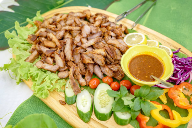 亚洲泰式烤猪肉，配以当地特有的酱汁，配以蔬菜黄瓜，绿橡木，红辣椒，薄荷柠檬。图片下载