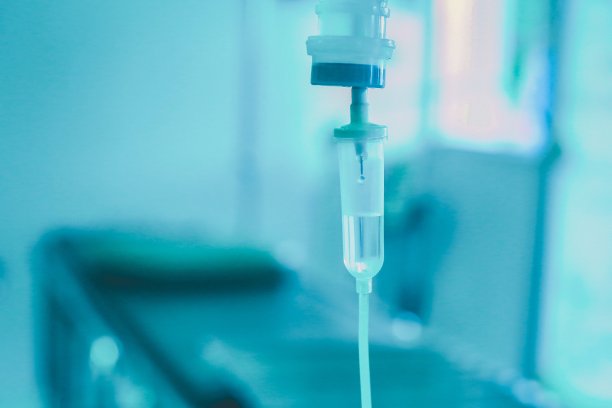 设静脉输液，静脉滴注生理盐水，医院病房点滴，医疗理念，治疗急诊，注射药物输液，护理化疗，理念。蓝光背景，选择性聚焦库存照片图片下载