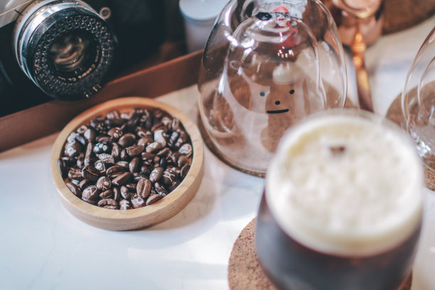 冰咖啡杯和烘焙咖啡豆放在木桌上，咖啡馆背景有复印空间图片下载